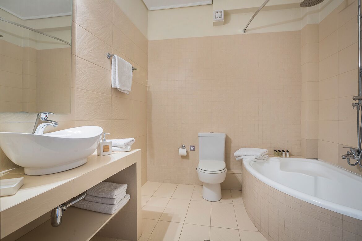 Ein modernes Badezimmer mit einer großen Badewanne, einem Waschbecken und einer Toilette.