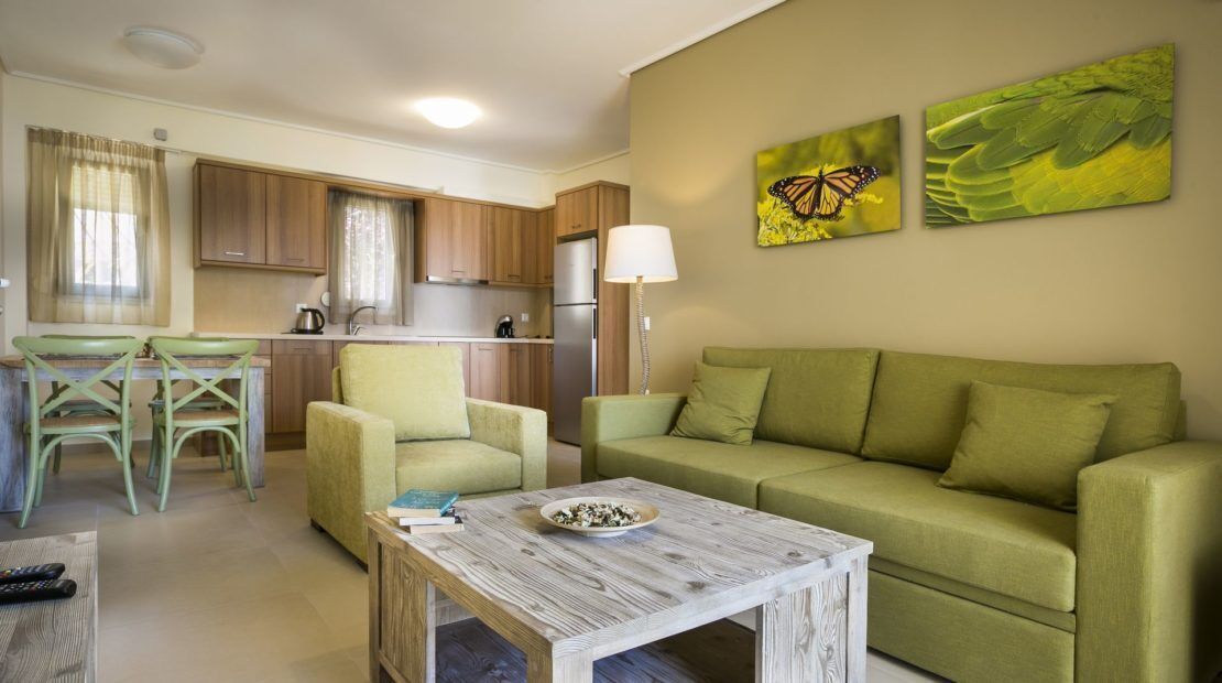 Een woonkamer met een bank, een salontafel, en een eethoek met stoelen en een tafel.