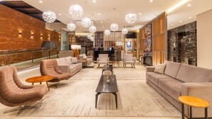 Un vestíbulo moderno con asientos cómodos, una mesa de centro y una iluminación decorativa.