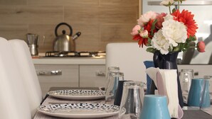 A dining table set with plates, cutlery, and a vase of flowers. - Speranzella 86 (Naples)
