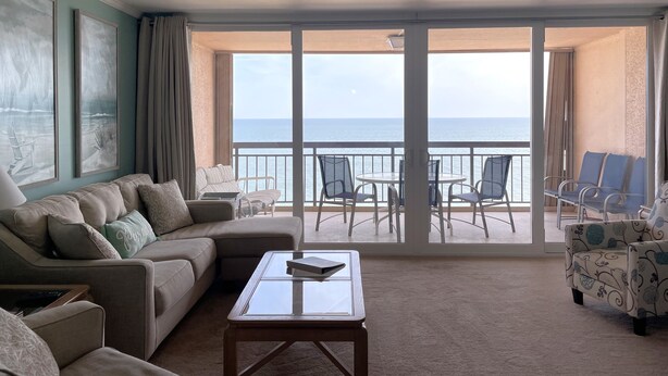 A spacious balcony with a view of the sea, furnished with a sofa, chairs, and a table. - Beach Front with Amazing Views from Oceanside & Bayside (Ocean City)