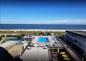 Enjoy the ocean view from our rooftop pool, surrounded by lounge chairs and umbrellas.