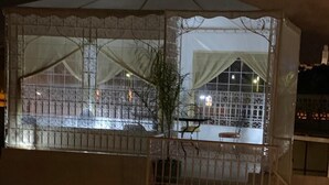 A multi-level building with a covered outdoor area, featuring a staircase and a railing. - Riad Najiba (Rabat)