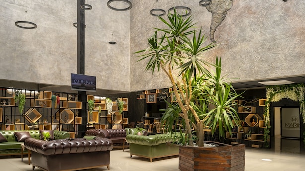 A spacious lobby with leather sofas, a large potted plant, and a world map on the ceiling. - Marinn Deluxe Hotel (Altinova)