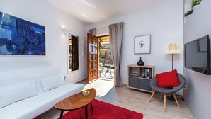 A modern living room with a white sofa, a red rug, a grey armchair, and a TV. - Romance Apartment Dubrovnik (Dubrovnik)