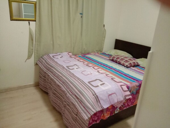 Cozy retreat with a single bed, striped bedspread, and decorative pillows.