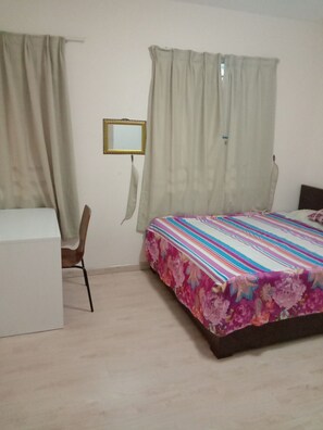 Cozy retreat with a single bed, desk, and chair, perfect for a relaxing stay.
