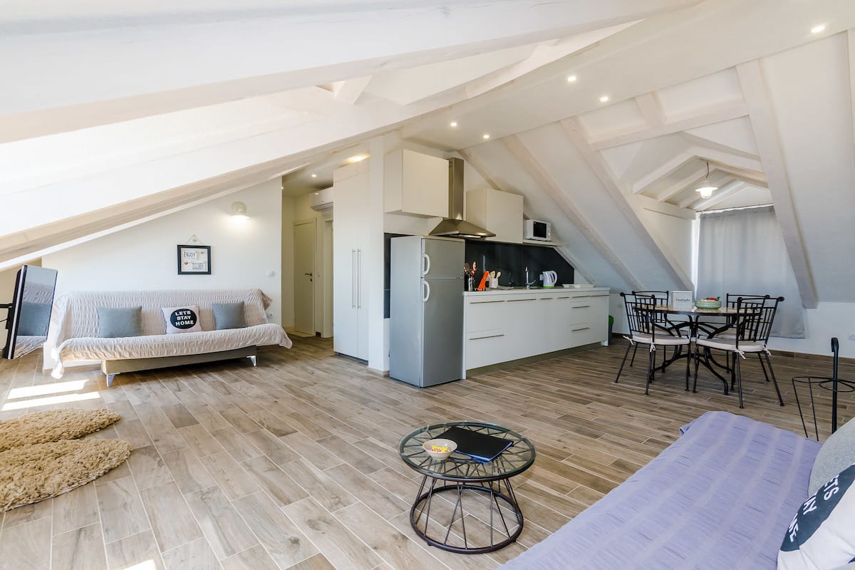 Un appartement moderne de style « loft » comprenant une cuisine, un coin repas et un espace de vie.