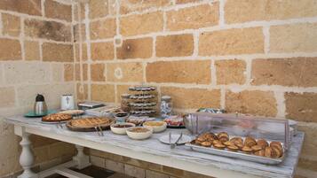 A buffet table with various food items and a coffee maker.