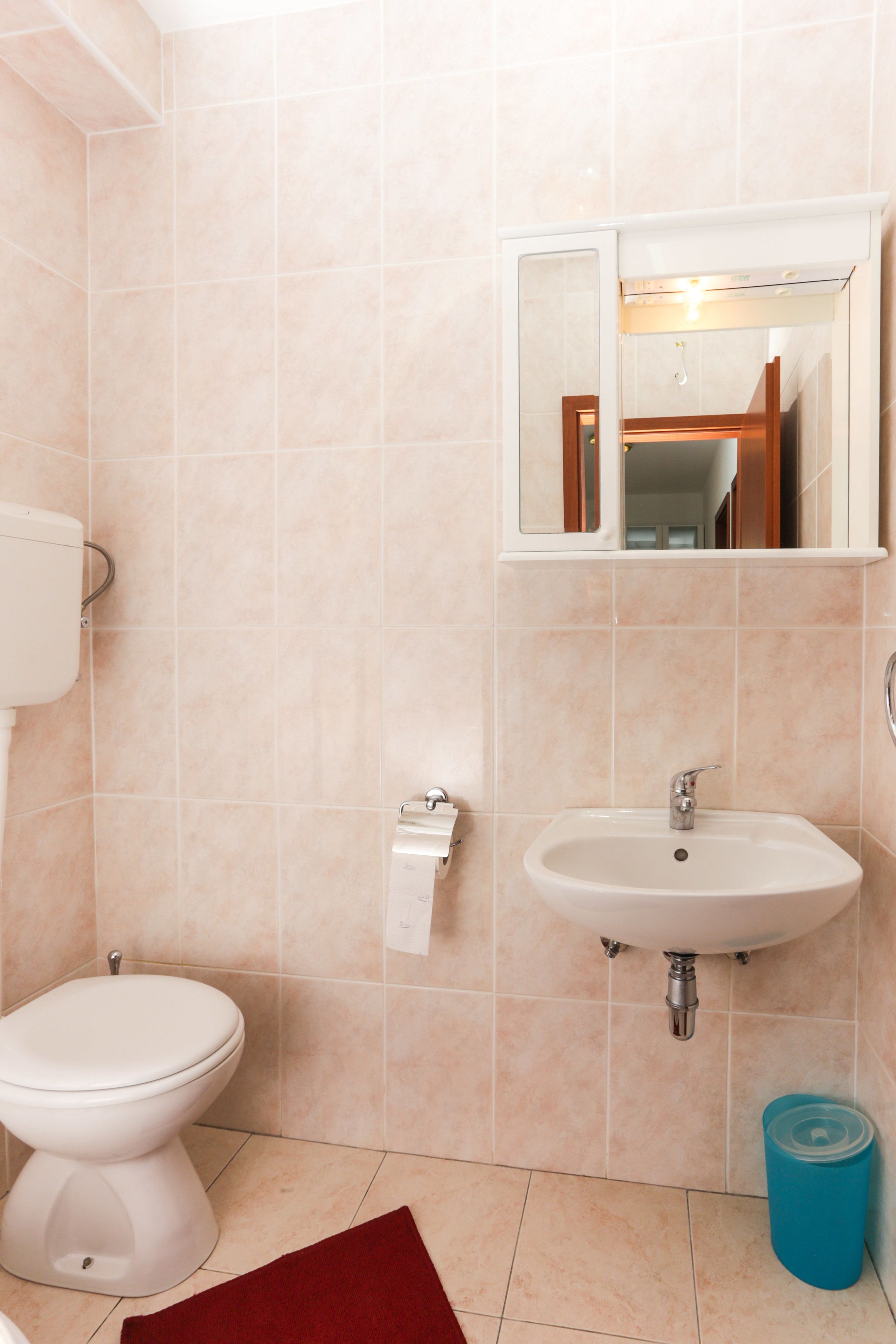 Ein Badezimmer mit Toilette, Waschbecken und Spiegel.
