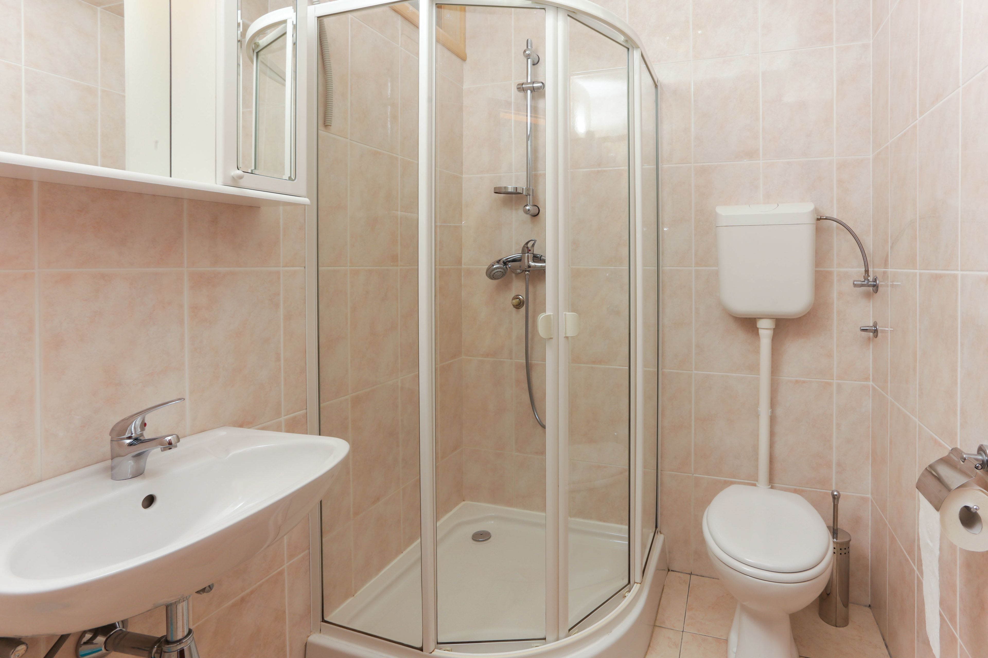 A modern bathroom with a glass-enclosed shower, a sink, and a toilet.
