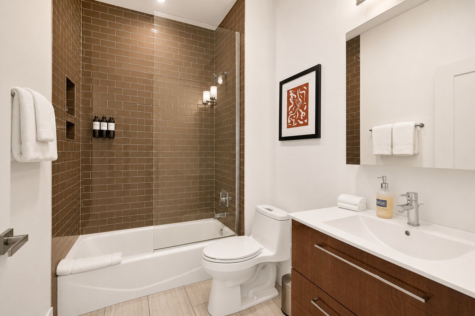 Une salle de bain moderne équipée d’une baignoire, de toilettes et d’un meuble-lavabo.
