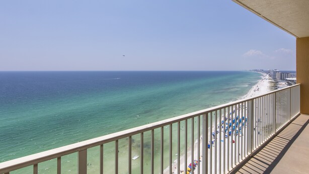 Ein Balkon mit Blick auf Strand und Meer.