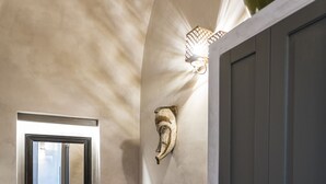 A room with a red velvet sofa, a grey door, and a patterned floor. - Al Console Luxury Suite (Monopoli)