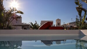 Una piscina cristalina que refleja los edificios y la vegetación circundante.