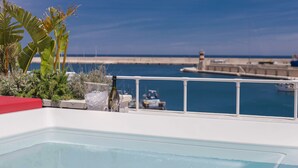 A pool area with a view of the sea and a pier in the background. - Al Console Luxury Suite (Monopoli)