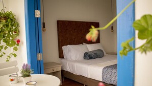 A bedroom with a bed, bedside table, and a small table with two cups. - El reloj casa hotel (Filandia)
