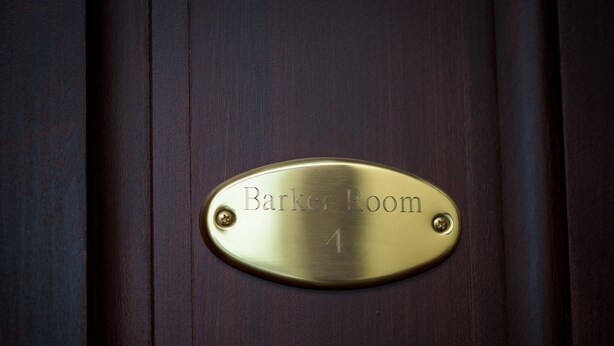 A brass plaque on a wooden door labeled "Barker Room 4".