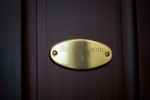 A brass plaque on a wooden door labeled "Barker Room 4". - The Hackett Hotel (Marietta)