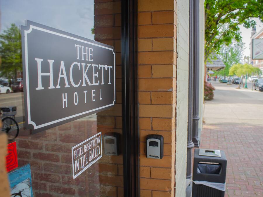 A hotel sign for "The Hackett Hotel" with a visible "Hotel Registration" sign below it.