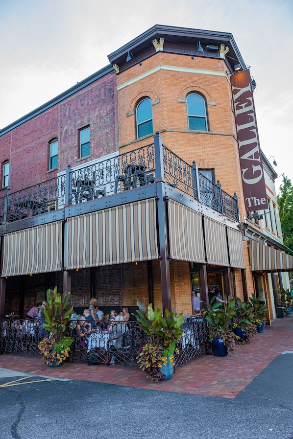 A corner building with a balcony and outdoor seating area. - The Hackett Hotel (Marietta)