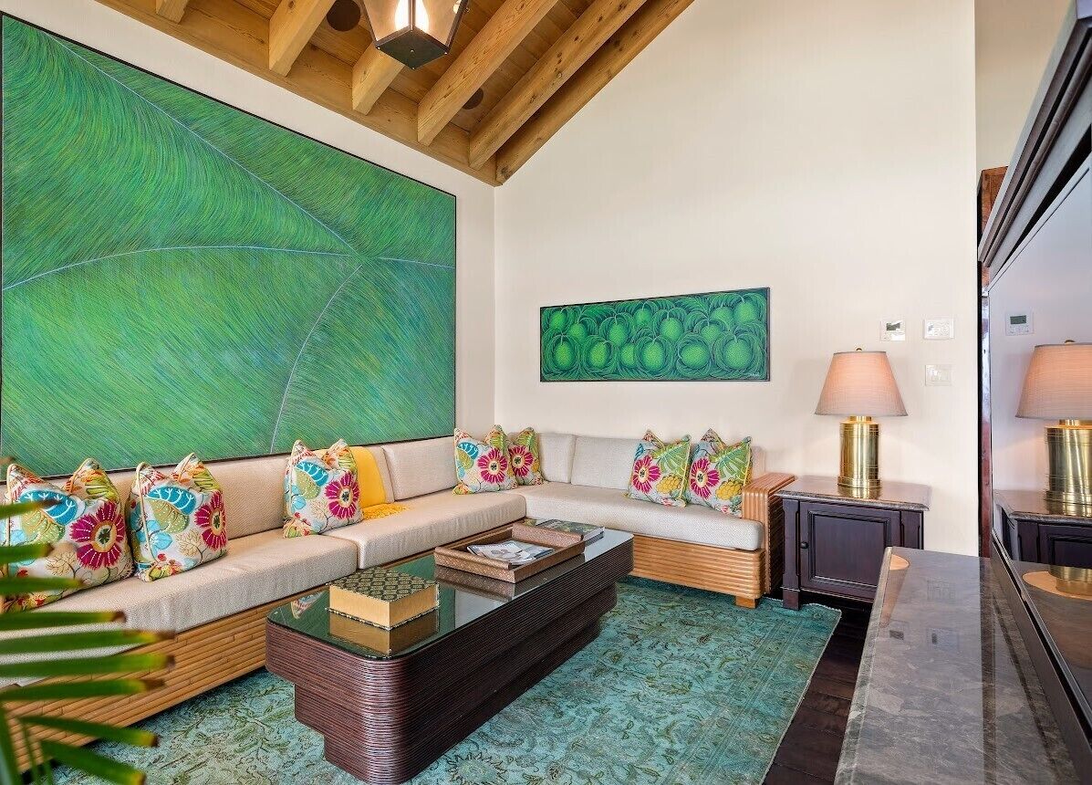 A modern living room with a sectional sofa, a coffee table, and a large abstract painting on the wall.