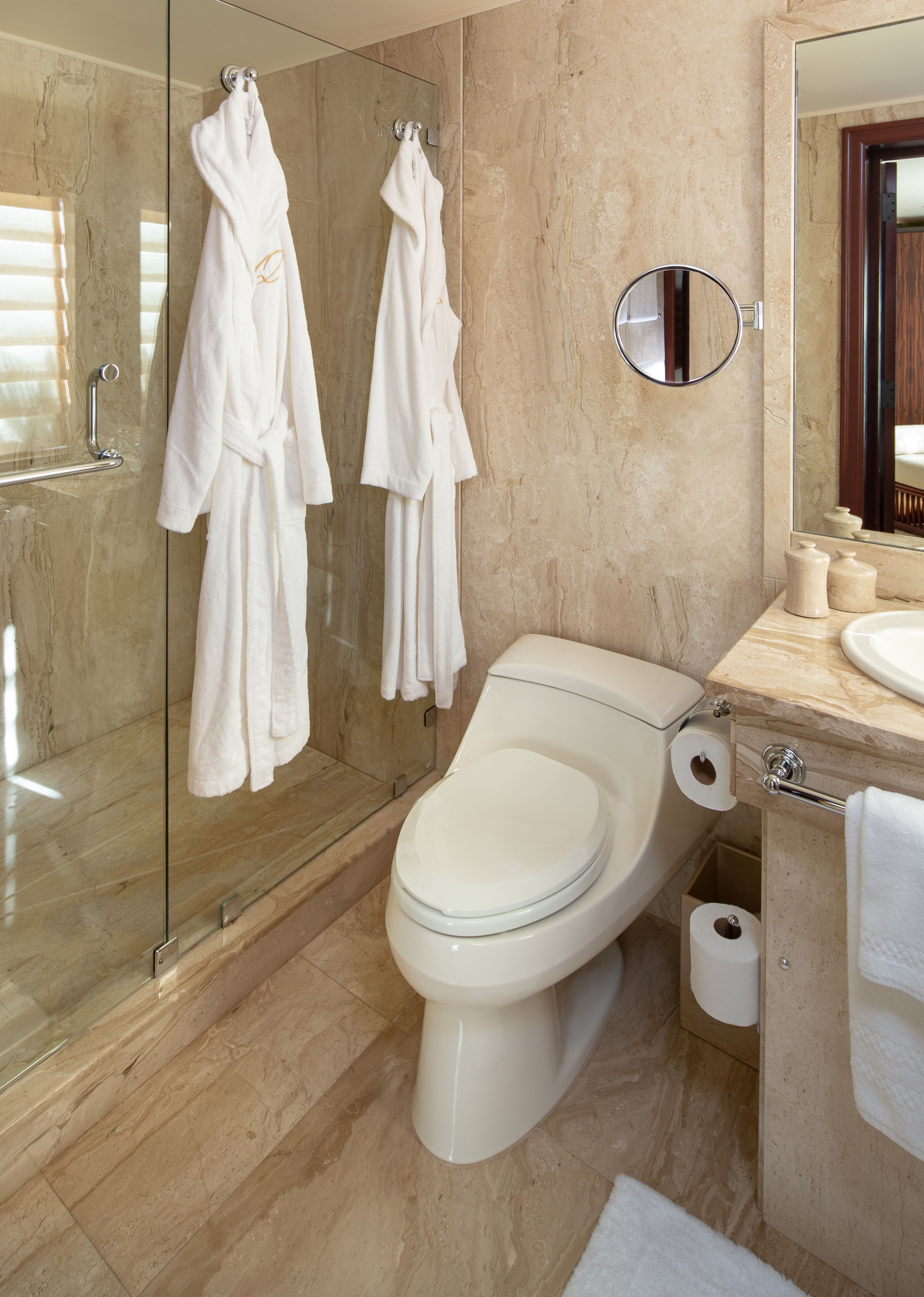 Un baño moderno con cabina de ducha de vidrio, inodoro y lavabo.