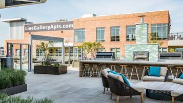 An outdoor patio area with seating, a bar, and a grill.