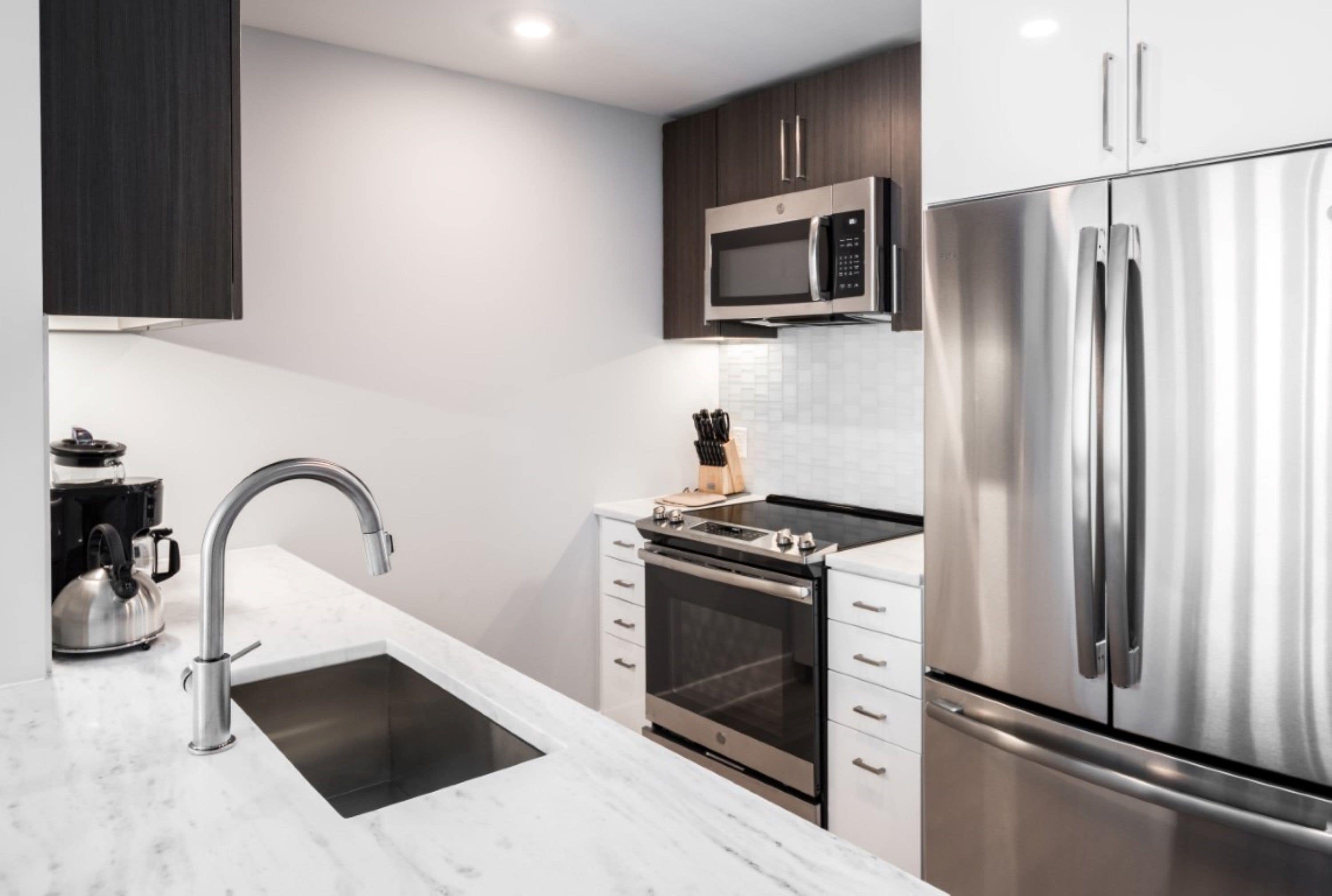 Una cocina moderna con electrodomésticos de acero inoxidable, horno integrado y microondas.