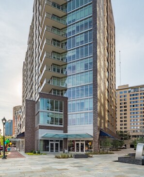 Um hotel moderno com vários andares, grandes janelas e design arquitetônico contemporâneo.