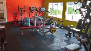 A gym with various exercise equipment, a bench, and a water bottle on a table. - Too's Nest Edoret (Eldoret)