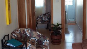 A living room with a sofa, a chair, a table, and a potted plant. - Too's Nest Edoret (Eldoret)