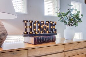 Welcome to a cozy retreat, where a warm sign and lush greenery create a peaceful atmosphere.