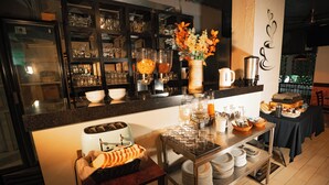 Una zona de cocina con barra libre, que incluye un cesto de pan, platos y diferentes alimentos.