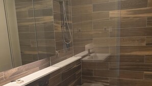 A modern bathroom with a glass shower enclosure, a white sink, and a toilet. - Modern 2b2b apartmemt. close to water front (Point Frederick)