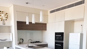 A modern kitchen with a central island, built-in appliances, and pendant lighting. - Modern 2b2b apartmemt. close to water front (Point Frederick)