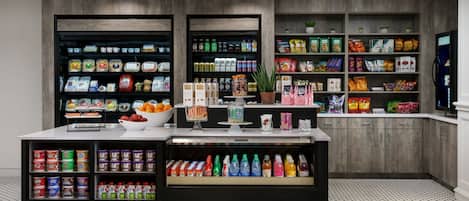 A well-organized snack and beverage display area with various products neatly arranged on shelves and in drawers.