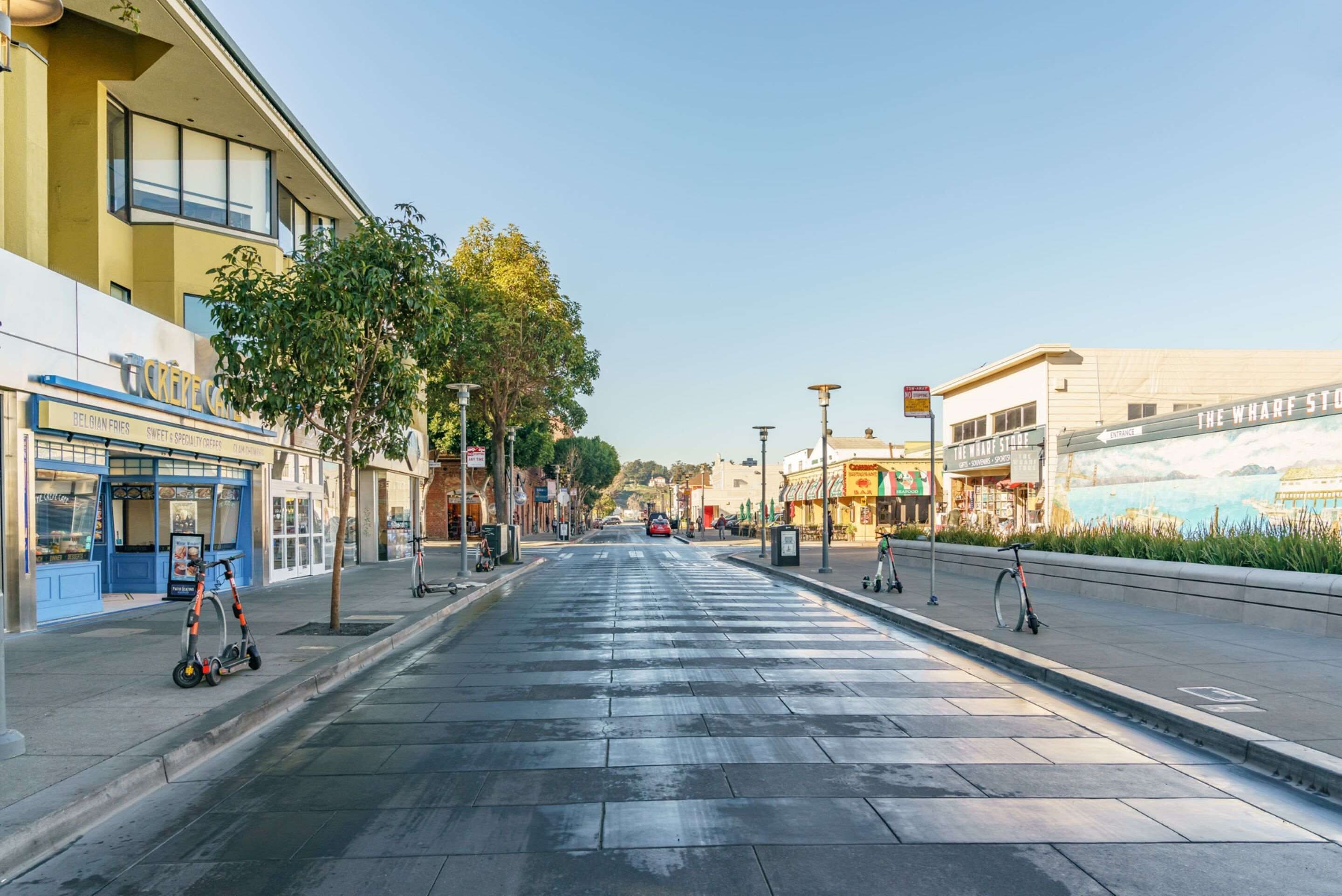 A street with shops, a bicycle, and a pedestrian crossing.