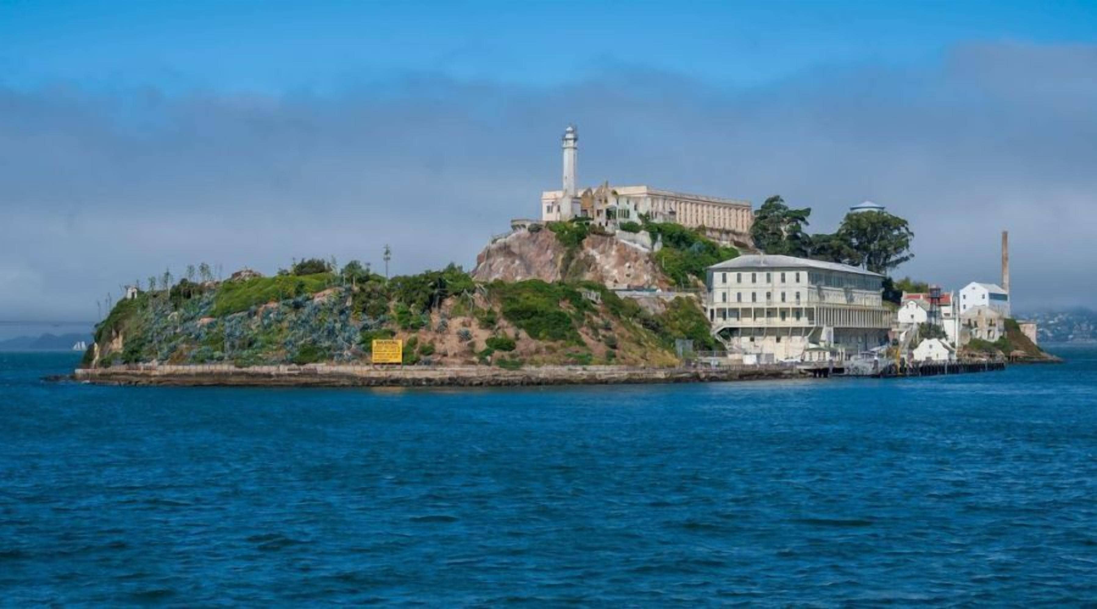 Un edificio costero con un faro, situado en una isla rocosa con vistas al mar.