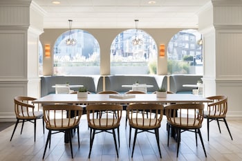 A stack of wooden blocks on a table in a modern lounge area with patterned cushions and a brick wall. at Hotel Caza Fisherman´s Wharf