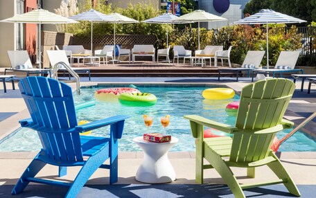 A pool area with lounge chairs and umbrellas.