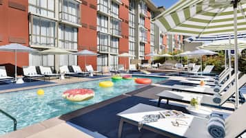 Alberca al aire libre, sombrillas en la alberca y camastros