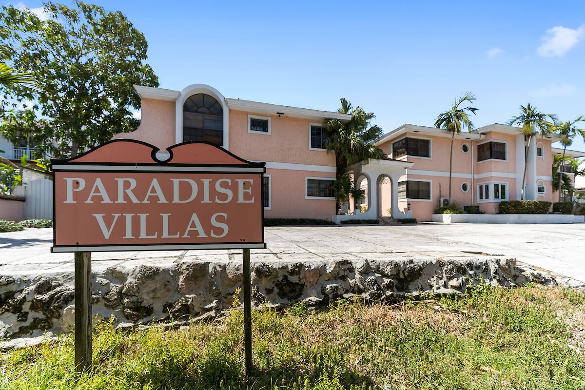 Une enseigne indiquant l’emplacement de « Paradise Villas », avec un bâtiment en arrière-plan.