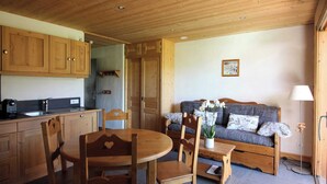 Un interior de madera con cocina, comedor y sofá.