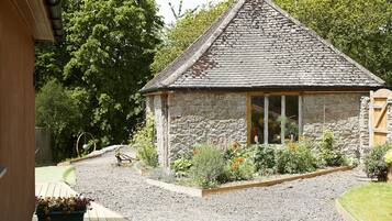 A stone building with a sloped roof and a window.
