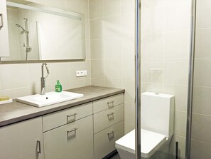 A bathroom with a white sink, a mirror, a shower, and a toilet. - In Paris, for 1 month or more! (Paris)