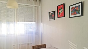 A dining area with a table, chairs, and two framed artworks on the wall. - In Paris, for 1 month or more! (Paris)