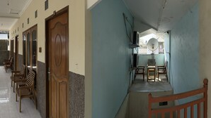 Un couloir avec des portes en bois, un espace détente avec des fauteuils et une antenne parabolique.