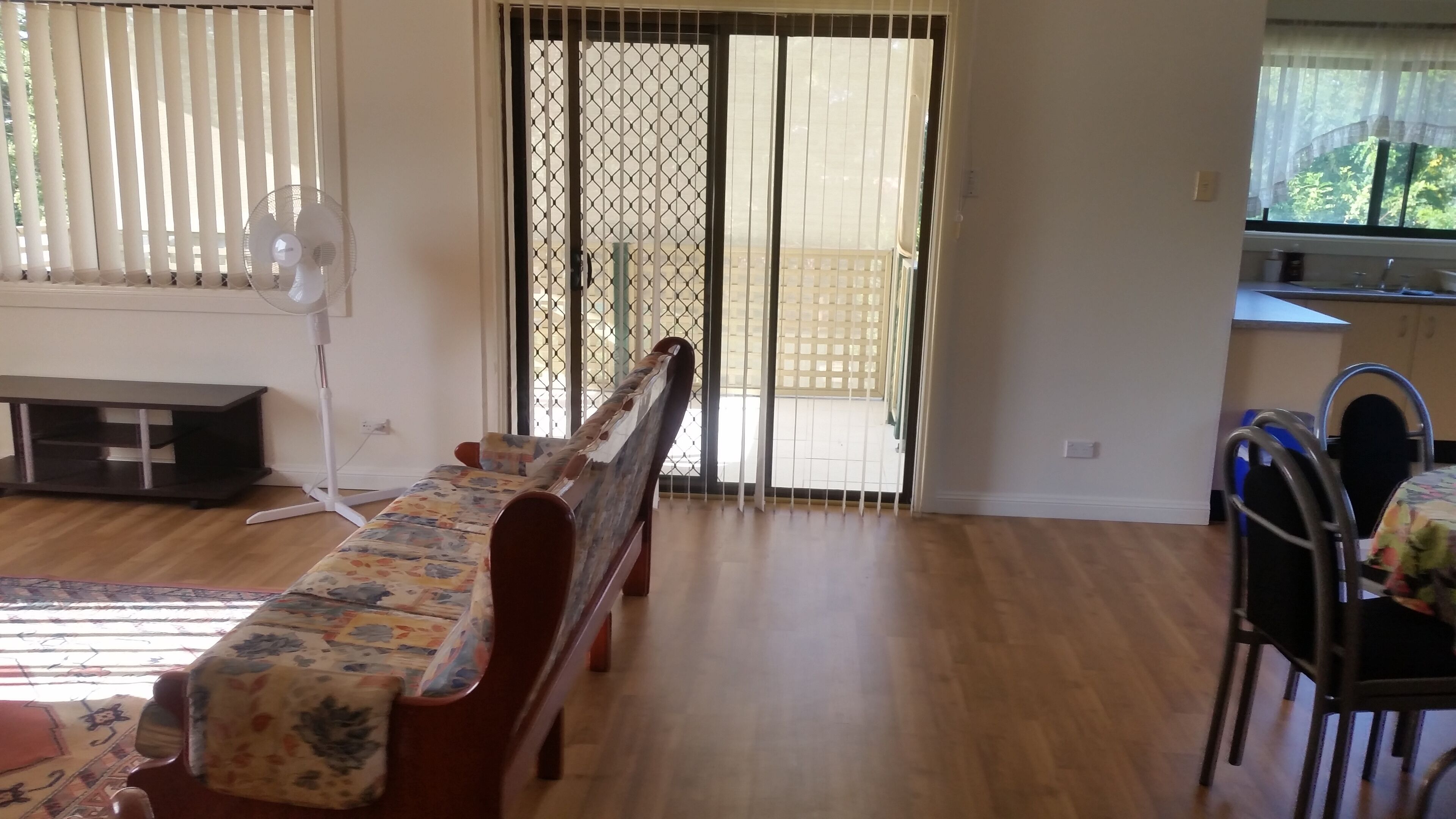 A room with a wooden ceiling, a window with metal bars, and a white radiator.