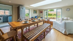 Une cuisine moderne avec un coin repas, un canapé et une vue sur le jardin.